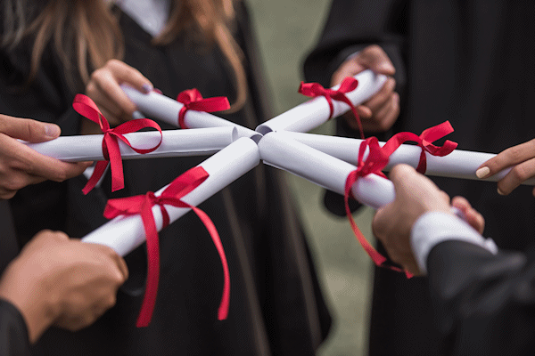 graduates holding diplomas together, making a circle
